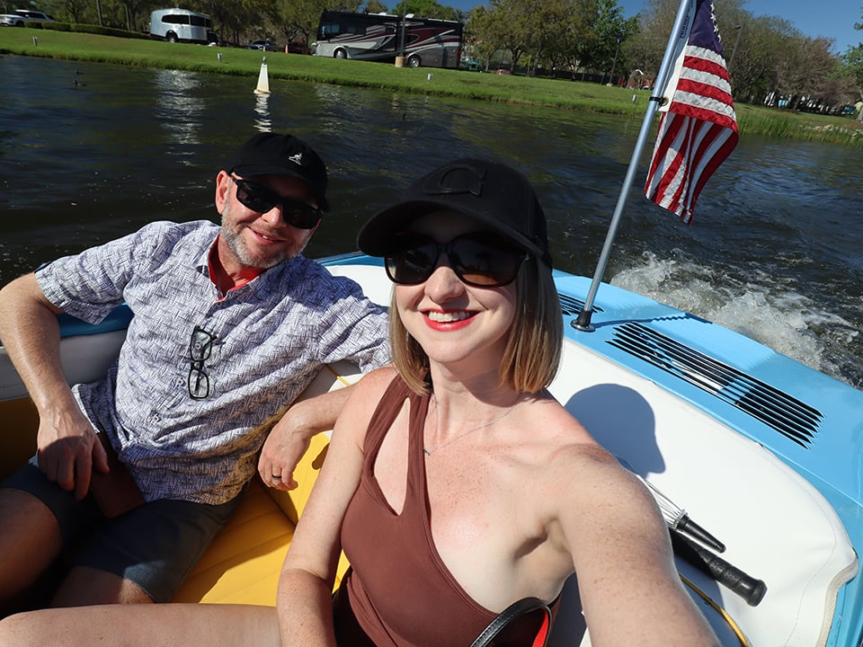 visitors ride on the water in a blue amphicar 
