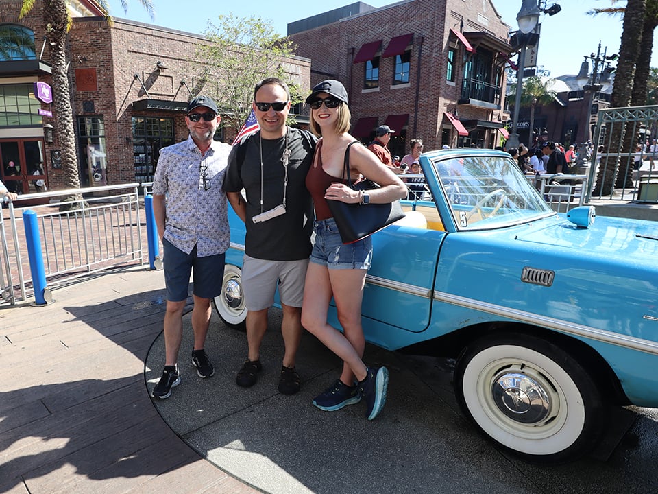 a group of people in front of the amphicar at disney springs