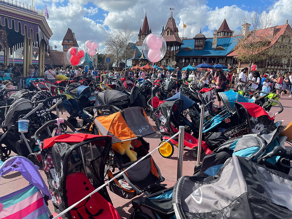 a row of strollers at disney with mickey balloons