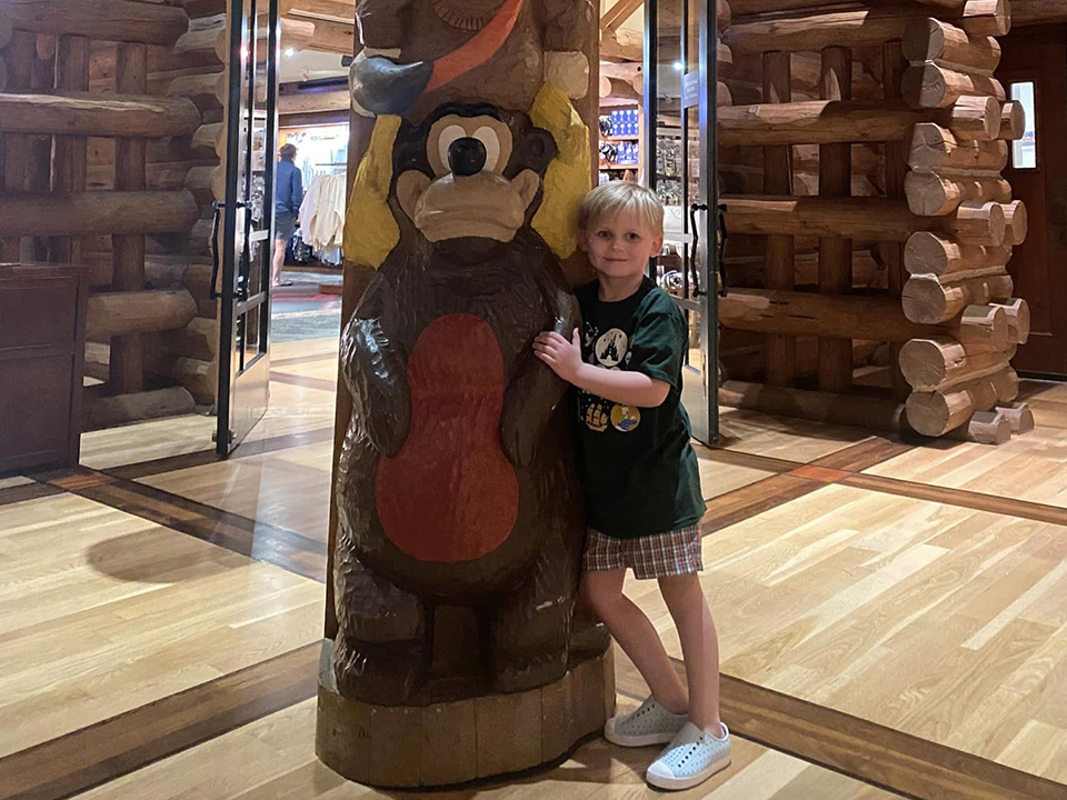 Child Hugging a Totem Pole At Disney's Wilderness Lodge