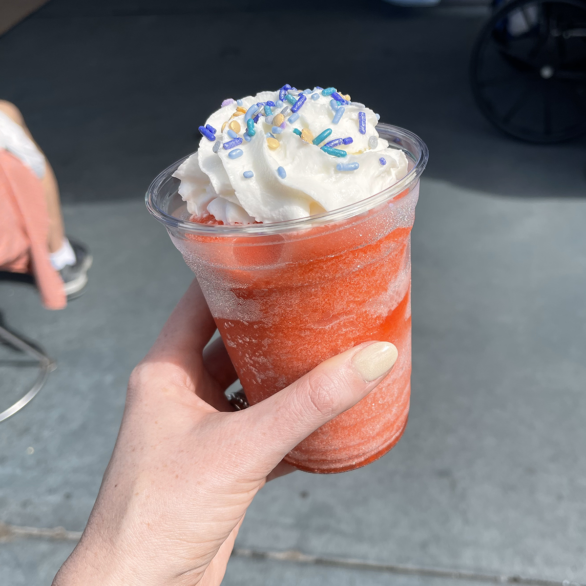 red slushy at magic kingdom with sprinkles and whipped cream