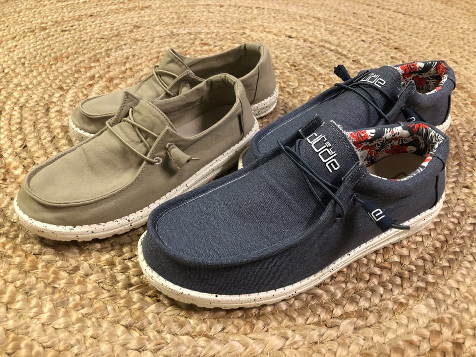 a green and dark blue pair of hey dudes