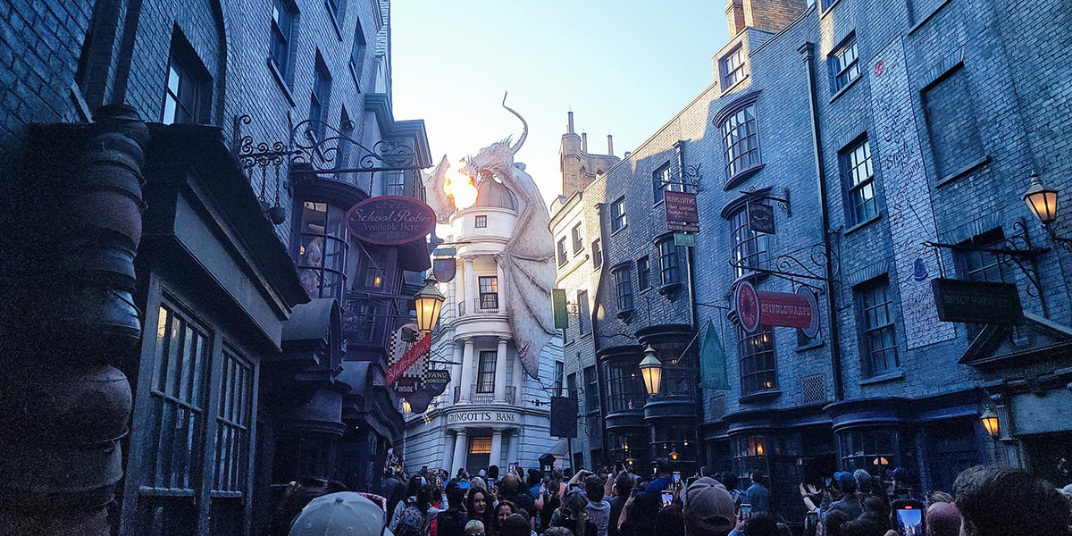 a view of diagon alley with fire breathing dragon above gringotts