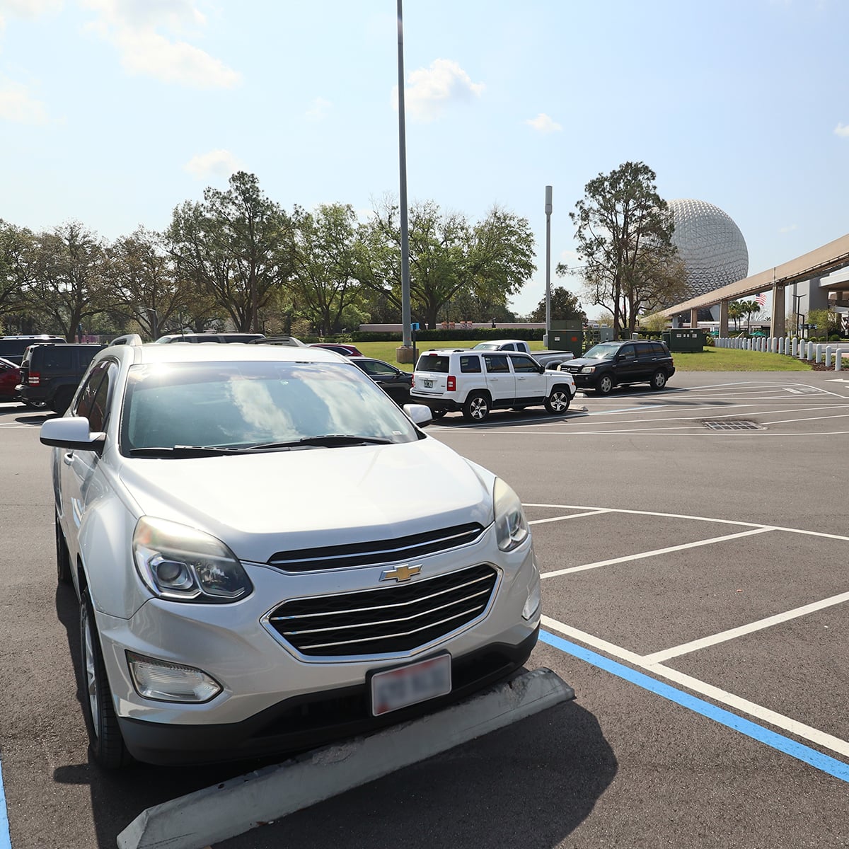 parking lot with epcot ball at disney world in the background