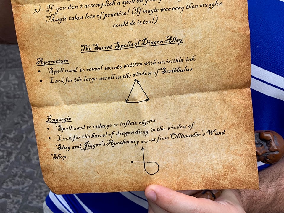 secret spells in diagon alley - one shows a triangle shape and the other shows a loop going from the left and then up 